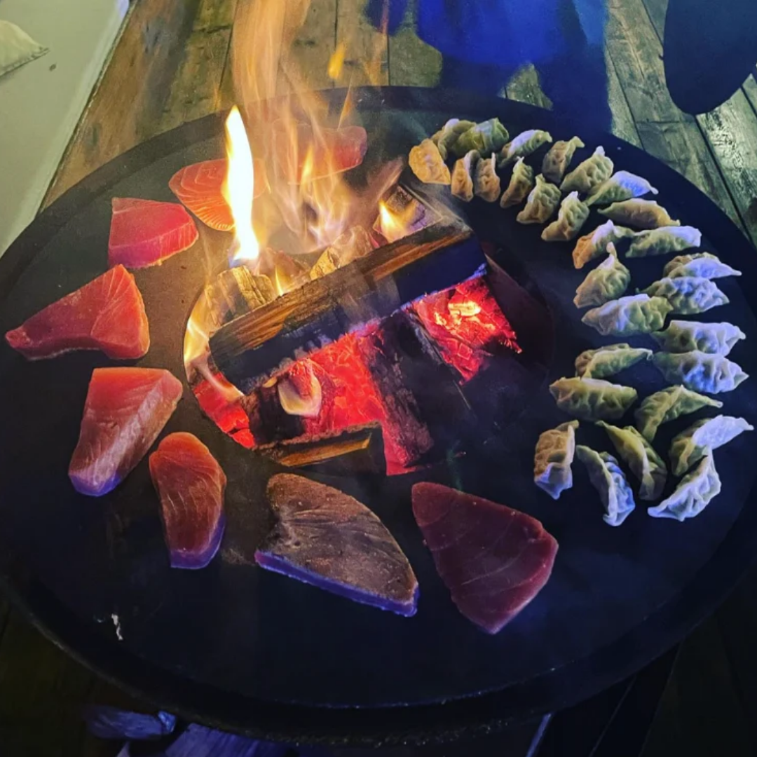 tonijn en gyoza's op bbq grillring open vuur