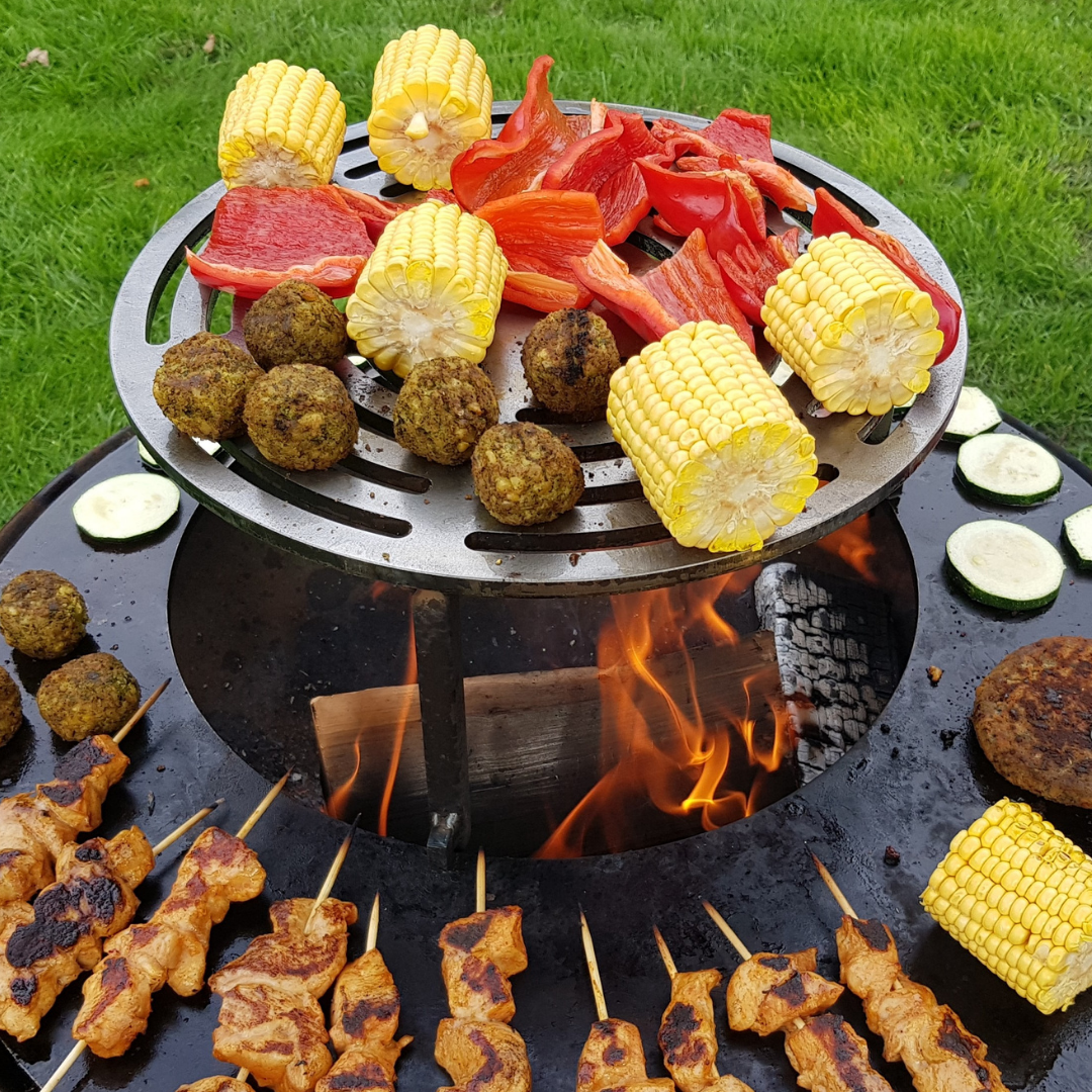 mais, paprika, kipspiesjes op grillring bbq boven vuur 