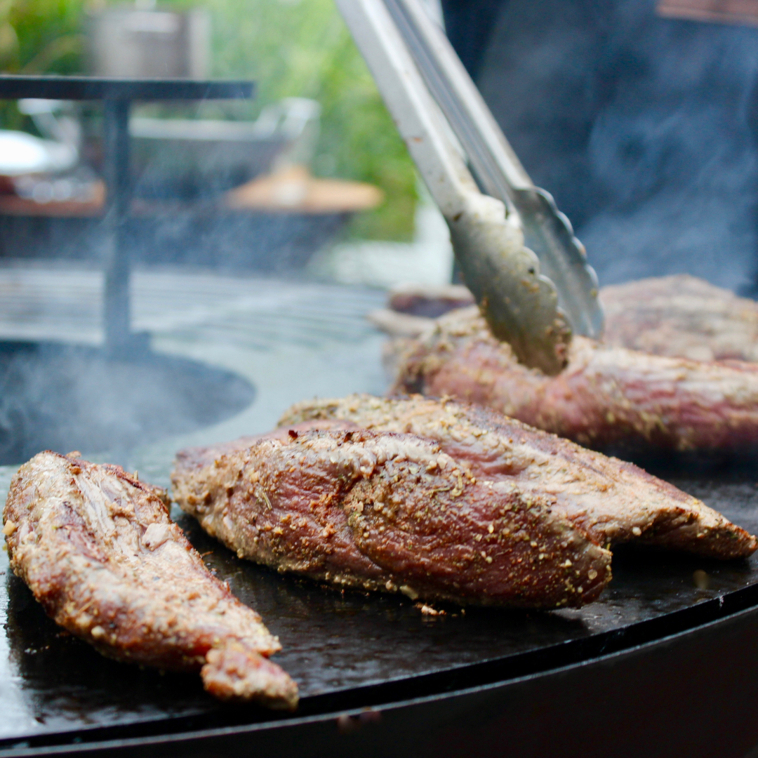 Procureur vlees grillen op bbq vuur grillring plancha