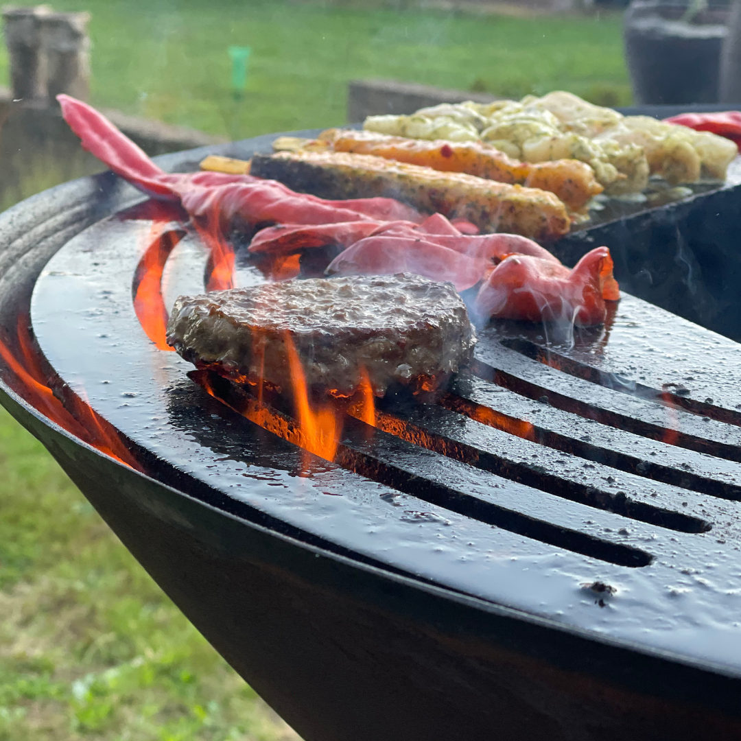 smash burgers maken op bbq grillring boven vuur